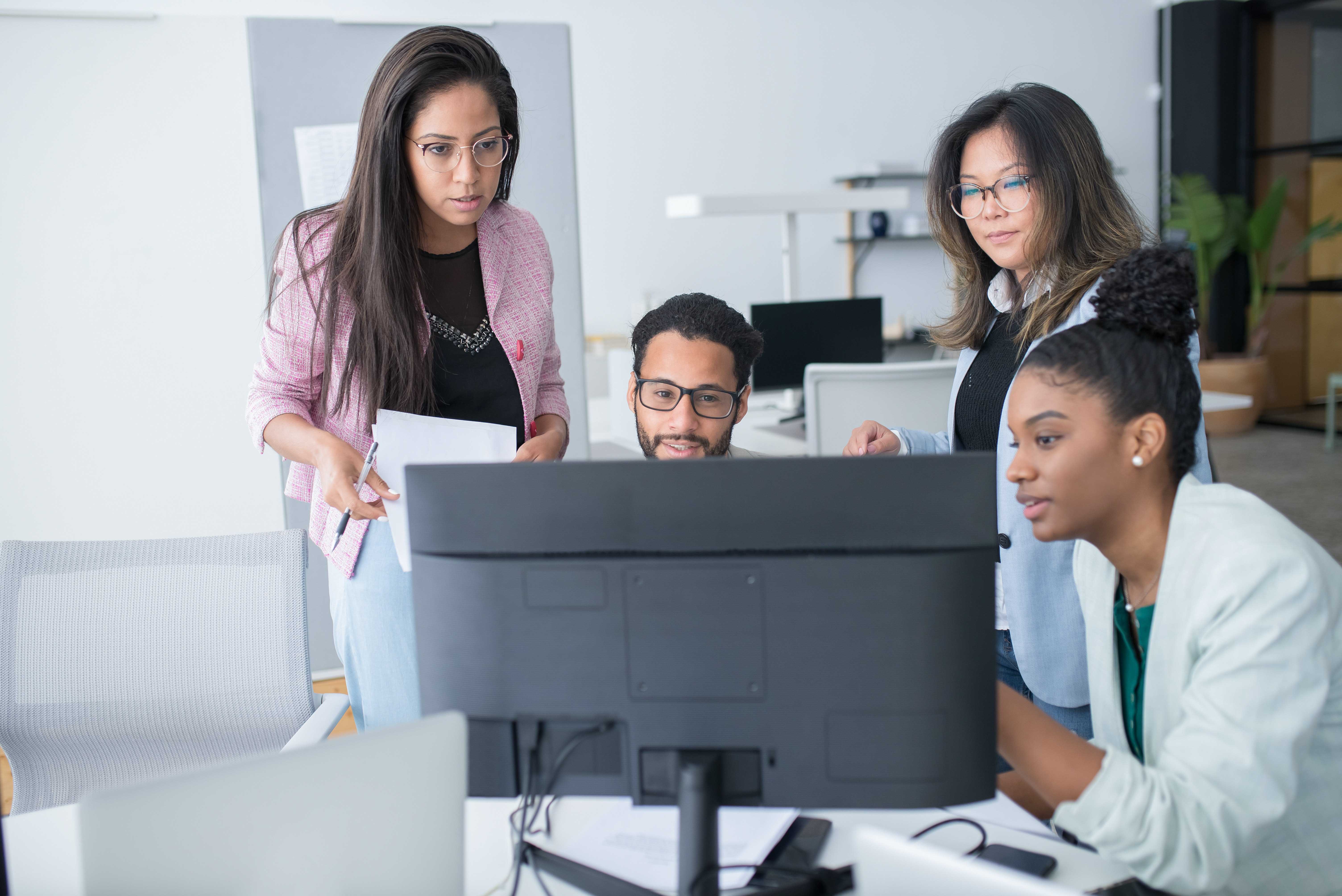 collaborative group of diverse workforce around computers